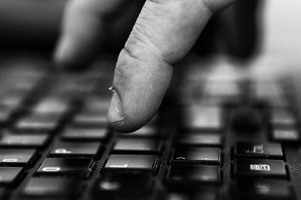 Hand typing on a keyboard representing employers affected by the H-1B extension fee