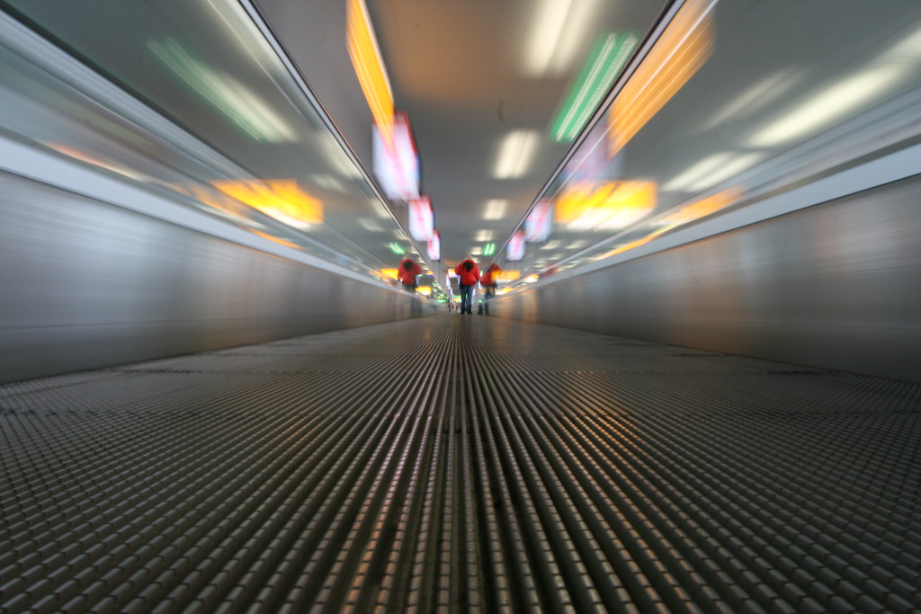 Travelers walking through an airport terminal representing the drop in Canada temporary resident arrivals